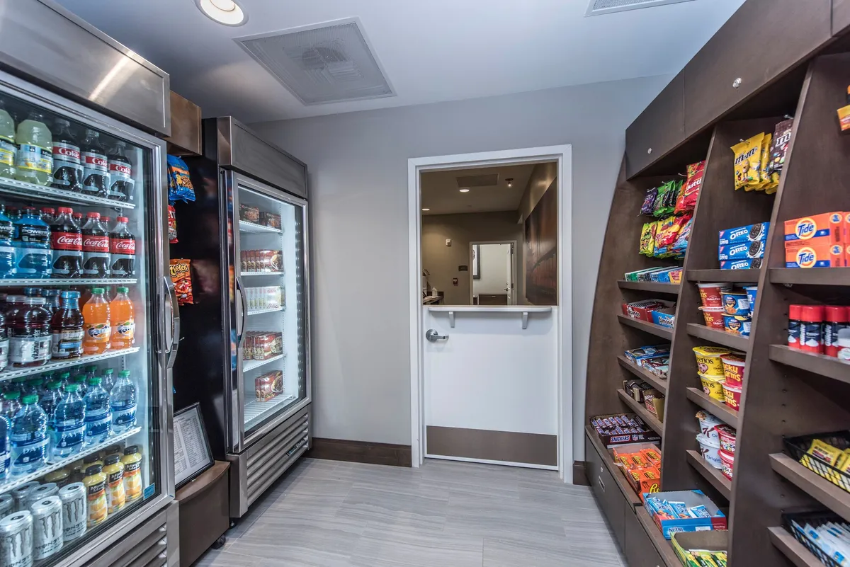A casual kitchenette area with a beverage fridge and snack shelf, inviting guests to grab refreshments on the go or share a quick bite with friends before heading out to explore.